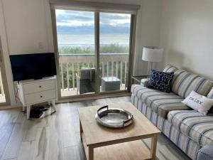 默特爾海灘的住宿－Sand Fiddler 101 condo，带沙发、桌子和电视的客厅