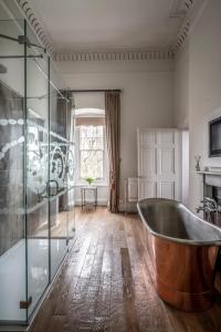uma casa de banho com uma banheira e um chuveiro em vidro. em Bailbrook House Hotel, Bath em Bath