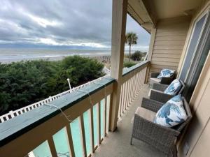 默特爾海灘的住宿－Sand Fiddler 101 condo，阳台配有椅子,享有海景。
