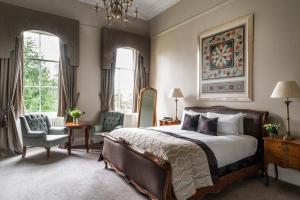 a bedroom with a bed and a chair and windows at Bailbrook House Hotel, Bath in Bath +35 photos