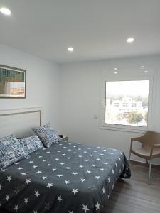 a bedroom with a bed and a chair and a window at Apartamento con vistas, entre mar y montaña in Hospitalet de l'Infant