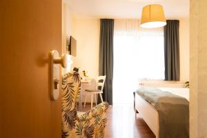 Zimmer mit einem Bett und einem Esszimmer mit einem Tisch in der Unterkunft Brauers Landarthotel GmbH in Daun