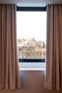 a window with a view of a building at Hapimag Apartments Amsterdam in Amsterdam