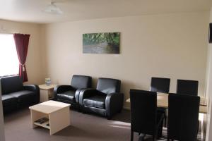 uma sala de espera com cadeiras e uma mesa em Alpine Rose Motel em Greymouth