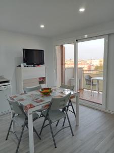 a dining room with a table and chairs and a television at Apartamento con vistas, entre mar y montaña in Hospitalet de l'Infant