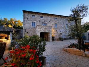 a large stone building with flowers in front of it at Casa della Grofica in Kringa