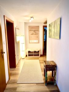 einen Flur mit einem Wohnzimmer mit Sofa und Teppich in der Unterkunft Appartement Maximilian in Tux