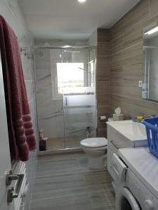 a bathroom with a toilet and a glass shower at Apartamento con vistas, entre mar y montaña in Hospitalet de l'Infant