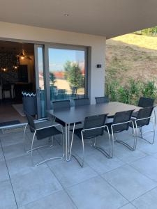 Une table à manger et des chaises noires sont disponibles sur la terrasse. dans l'établissement TheGuthPlace, à Rouffach