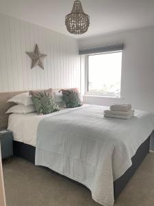 a bedroom with a large bed with a large window at Westward 14 Polzeath in Polzeath