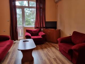 a living room with red furniture and a table at Family Hotel RUJETA Семеен Хотел РУЖЕТА - идеален център in Pawlikeni