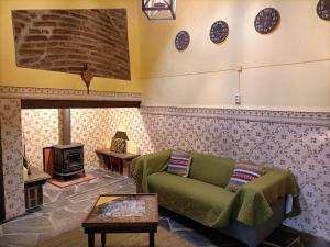 a living room with a couch and clocks on the wall at Casa do Beco in Monsaraz
