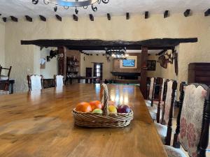 a basket of fruit sitting on a wooden table at Casa rural Finca Requejo cerca de Benavente TR 49426 in Manganeses de la Polvorosa