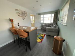 a kitchen and living room with a table and a couch at Orchard Cottage. in Lincoln