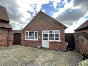 a brick house with a white door at Orchard Cottage. in Lincoln