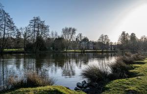 a large lake with a house in the background at Chilston Park Hotel in Lenham