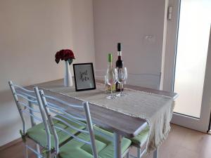 a table with two chairs and wine glasses on it at Apartments Pulic in Skradin