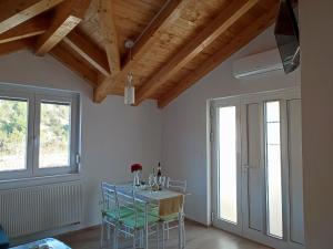 a dining room with a table and chairs and windows at Apartments Pulic in Skradin