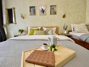a bedroom with two beds and a tray with a cup of coffee at Мини-отель ДАРЬЯ в Пицунде in Pizunda