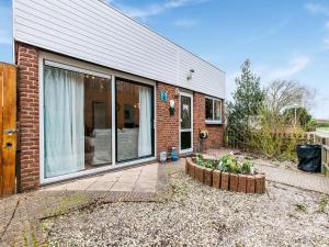 uma casa de tijolos com uma janela e um pátio em Endearing Holiday Home in Noordwijkerhout with Garden BBQ em Noordwijkerhout