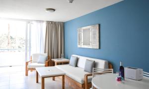 a living room with a white couch and a blue wall at Playa Del Sol - Adults Only in Playa del Ingles