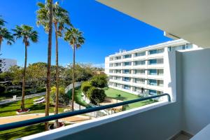 a balcony with palm trees and a building at Playa Del Sol - Adults Only in Playa del Ingles