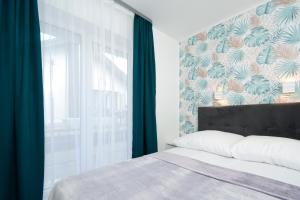 a bedroom with a bed and a large window at Apartamenty Prestige in Łeba