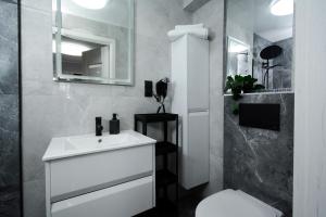 a bathroom with a sink and a toilet and a mirror at Apartamenty Prestige in Łeba +70 photos