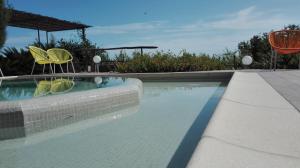 a swimming pool with two chairs and an umbrella at Oroverde in Bergeggi