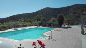 a large swimming pool with a mountain in the background at Oroverde in Bergeggi
