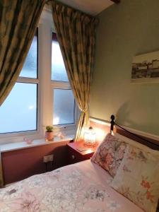 ein Schlafzimmer mit einem Bett und zwei Fenstern in der Unterkunft Longcroft Lodge in Bridlington