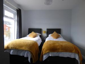 a bedroom with two beds with blankets and a window at Bare Village Holiday Apartment in Bare