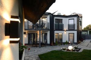 uma casa branca com uma varanda e um pátio em Apartamenty Prestige em Łeba