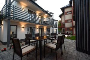 a dining table and chairs on a patio at Apartamenty Prestige in Łeba