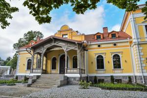 an old yellow building with a roof at Schloss Fellin Boutique Hotel and Spa in Viljandi