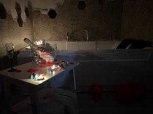 a dark room with a tub and a table with candles at lapietra_hotelescapes in San Gennaro Vesuviano