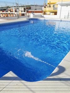 una gran piscina de agua azul en Coquina 10 Apartamento, en Punta Umbría