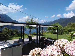 a patio with chairs and a view of the mountains at Essentia Guest House in Faggeto Lario 