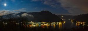 a view of a town on the water at night at Essentia Guest House in Faggeto Lario 