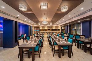 a restaurant with wooden tables and chairs and blue walls at LA GRRANDE MALAR in Puducherry