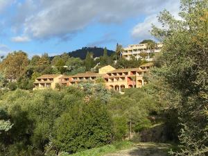 a building on top of a hill with trees at Les Terrasses du Mirage grand T2 in Bormes-les-Mimosas
