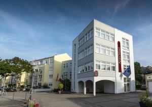 a white building with a sign on the side of it at Apart' Hotel in Kehl am Rhein