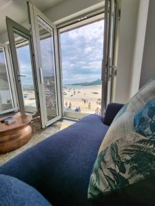 a living room with a couch and a view of the beach at Chy Mor Apartment 1 in St Ives