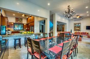 a dining room with a long table and a kitchen at Mansion Villa in Soliman Bay for 34 guests! in Tulum