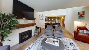 a living room with a fireplace and a tv at Greyhawk by Whistler Premier in Whistler