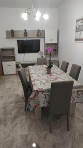 comedor con mesa, sillas y TV en Casa D'Amico, en Arnesano