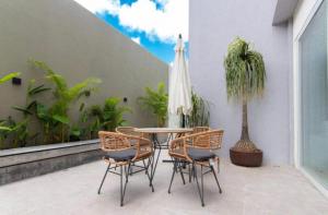 um pátio com uma mesa e cadeiras e uma palmeira em Bauten Cabo Branco - Flat uma quadra da praia em João Pessoa