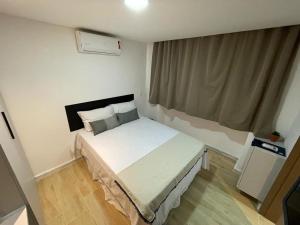 um quarto com uma cama branca em um quarto em Bauten Cabo Branco - Flat uma quadra da praia em João Pessoa mais 12 fotografias