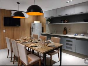 uma mesa de jantar com cadeiras e uma cozinha em Bauten Cabo Branco - Flat uma quadra da praia em João Pessoa