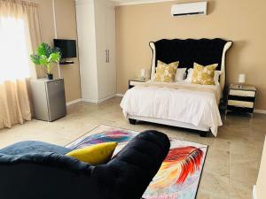 莱迪史密斯Aaron's Nest Bed and Breakfast的一间卧室配有一张床、一把椅子和一张沙发